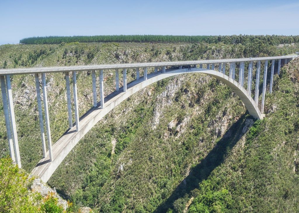 Der Betonbogen der Bloukrans Bridge überspannt eine tiefe bewaldete Schlucht an der Garden Route Südafrikas.